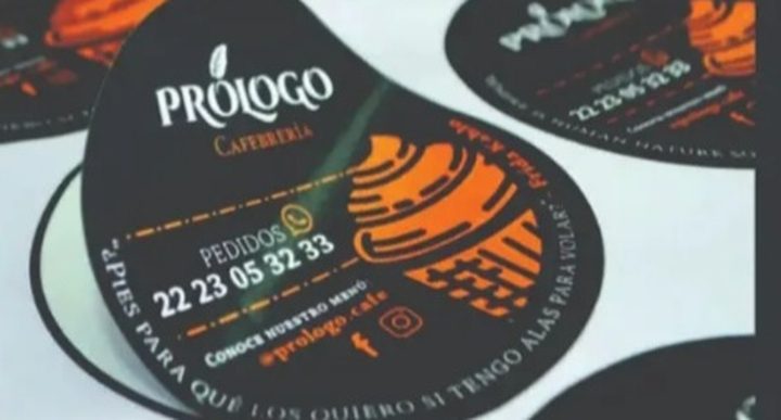 Exemplo ilustrativo de adesivos redondos personalizados, com um deles sendo descolado da folha